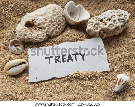 Treaty writing on beach sand background.