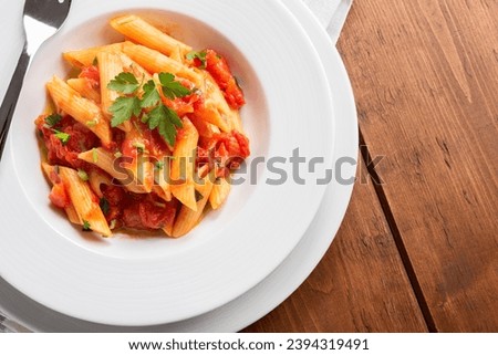 Penne all'arrabbiata, a traditional recipe of italian pasta, european food  Royalty-Free Stock Photo #2394319491