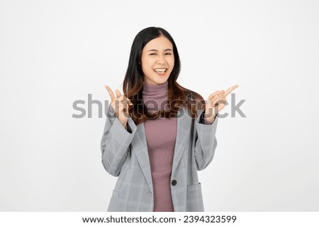 Young asian business woman, smiling while pointing finger, recommending product, praise, standing over white background.