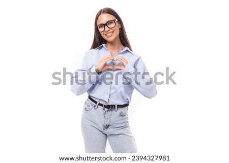 attractive well-groomed young brunette caucasian woman in glasses is dressed in a sky blue shirt on a white background with copy space