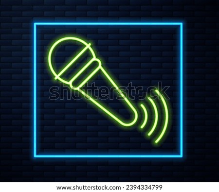 Glowing neon line Wireless microphone icon isolated on brick wall background. On air radio mic microphone. Speaker sign.  Vector