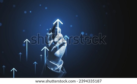 Hand reaching towards upward arrows, symbolizing growth, increase, and positive trends in dark setting Royalty-Free Stock Photo #2394335187