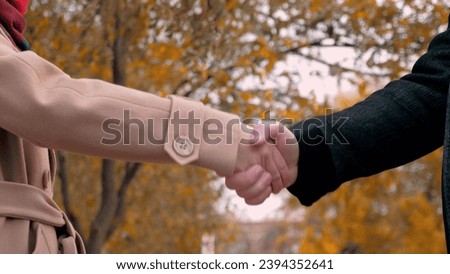 Man and woman work partners shake hands to sign contract at meeting in park