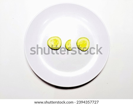 sliced cucumber on white plate isolated in white background. healty cucumbers for diet food. 