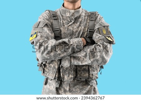Male soldier with Ukrainian chevrons on blue background