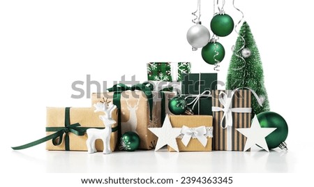 Various wrapped Christmas Gift boxes set with green balls and baubles isolated on white background.