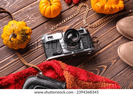 Composition with female clothes, accessories and pumpkins on wooden background