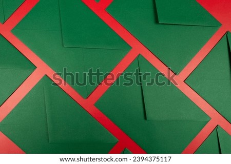 Top view of green envelopes on red background. Christmas, New Year composition. Post flat lay, copy space.