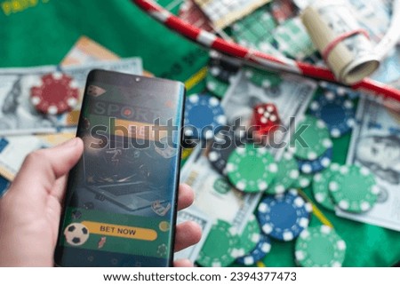 Sports betting website in a mobile phone screen, ball, money