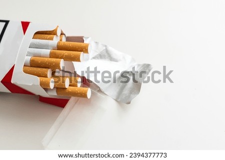 Pack full of filtered cigarettes on white isolated background.