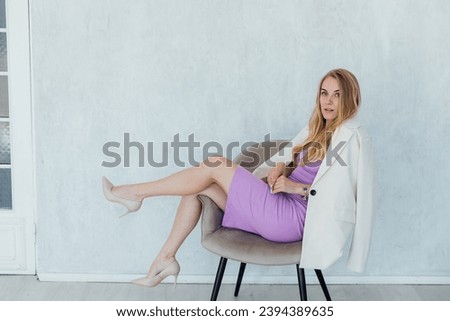 blonde woman in business purple dress in office