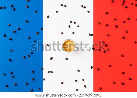 Creative layout made of cup of coffee and coffee beans on flag of France as a background. Minimal coffee concept. Trendy espresso idea. Unique flat lay composition. Coffee aesthetic.