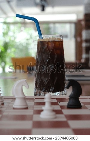 ice americano and chess pieces on the chessboard in the cafe