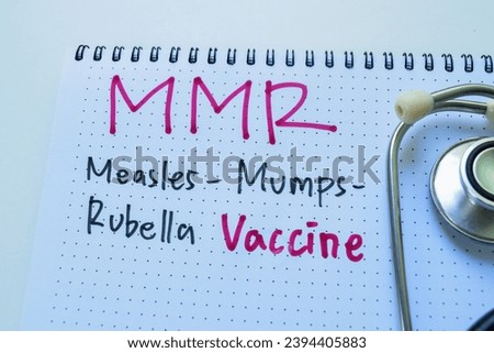 Concept of MMR - Measles Mumps Rubella Vaccine write on book with stethoscope isolated on white background. Royalty-Free Stock Photo #2394405883