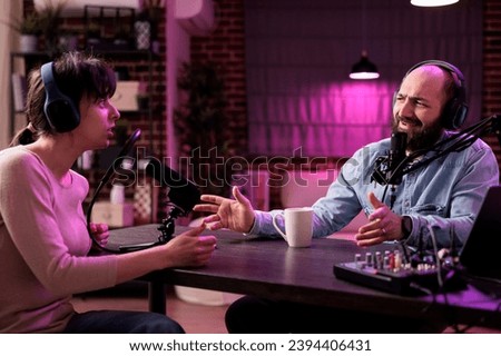 Show host interviewing woman during live stream, talking about fashion and style trends, disagreeing with her opinions. Man arguing with social media celebrity, recording podcast Royalty-Free Stock Photo #2394406431