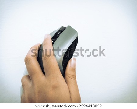 A picture of a hand holding a wireless mouse. 