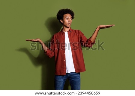 Photo portrait of handsome young guy palms advantage compare empty space wear trendy brown outfit isolated on khaki color background