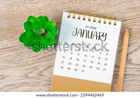 January 2024 monthly desk calendar and pencil with plant pot decoration on wooden background. Royalty-Free Stock Photo #2394462469