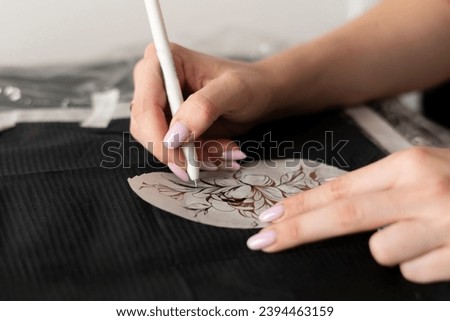 a caucasian woman making tattoo sketch on paper in the office