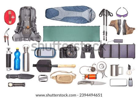 Set of tourist trekking items on white background. Top view of accessories for travel. Equipment for travel and hiking. Survival Items. Royalty-Free Stock Photo #2394494651