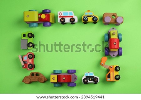 Frame of different toy vehicles for children on green background, flat lay. Space for text