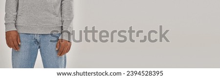 elegant young african american man in sweatshirt and jeans, copy space for advertising, banner