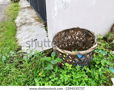 A bamboo basket in front of the house is very useful for trash cans 
