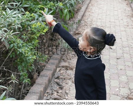Baby girl playing with dry green leaves.Beautiful kid open mouth and making different style of hands.Portrait photography using for wallpaper. 