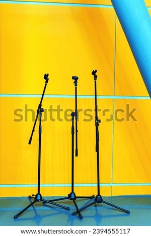 Three empty microphone stands on stage
