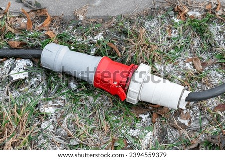 The power supply connection for outdoor equipment lies on the ground. outdoor power connector Royalty-Free Stock Photo #2394559379