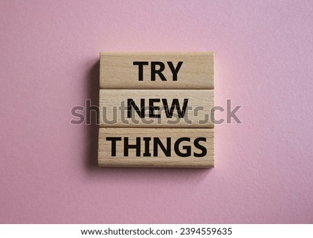 Try new Things symbol. Concept words Try new Things on wooden blocks. Beautiful pink background. Business and Try new Things concept. Copy space. Royalty-Free Stock Photo #2394559635