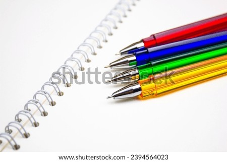 Ballpoint pens. Choice of handles. Colored pens. Ink pens for writing. Pens lie on the notepad page. Office stationery concept. Royalty-Free Stock Photo #2394564023