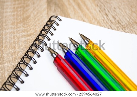 Ballpoint pens. Choice of handles. Colored pens. Ink pens for writing. Pens lie on the notepad page. Office stationery concept. Royalty-Free Stock Photo #2394564027