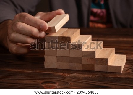 a business man build a blocks wood game. Royalty-Free Stock Photo #2394564851
