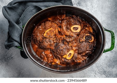 Osso buco cross cut veal shank braised with tomatoes and spices, beef meat Ossobuco. White background. Top view Royalty-Free Stock Photo #2394566489