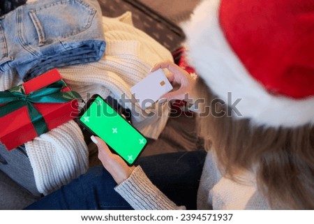 Woman uses smartphone and credit card. Mockup for application or service. Christmas shopping.