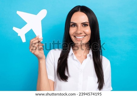 Photo of cheerful good mood girl dressed white shirt rising plane card isolated blue color background