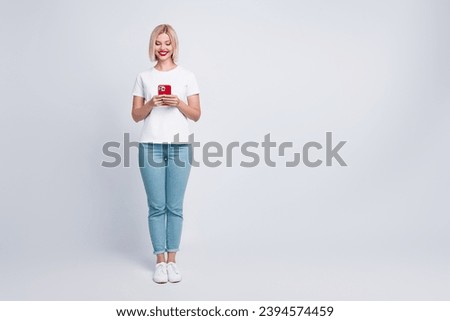 Full size photo of positive cheerful girl with bob hairdo dressed white t-shirt read email on smartphone isolated on gray color background
