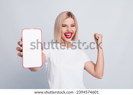 Photo of ecstatic satisfied woman dressed white t-shirt demonstrate smartphone display win lottery isolated on white color background