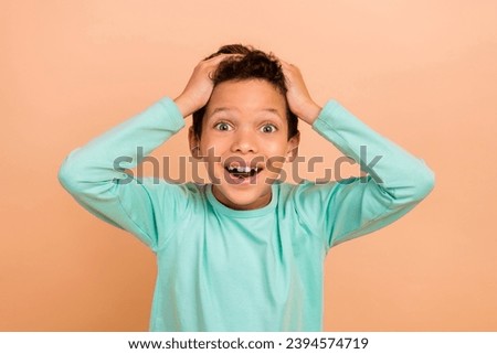 Photo of overjoyed cheerful glad boy wear trendy turquoise clothes unexpected unbelievable success isolated on beige color background Royalty-Free Stock Photo #2394574719