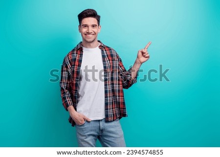 Photo of funky sweet guy wear checkered shirt showing finger empty space isolated blue teal color background