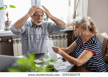 Senior couple discussing their home finances while sitting at the table Royalty-Free Stock Photo #2394583579