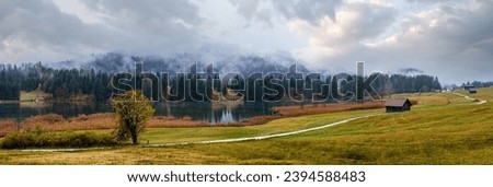 Alpine  lake Geroldee or Wagenbruchsee, Bavaria, Germany. Autumn overcast, foggy and drizzle day. Picturesque traveling, seasonal, weather, and rural nature beauty concept scene. Royalty-Free Stock Photo #2394588483