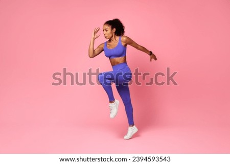 Athletic African American Lady In Fitwear Jumping Exercising During Training Over Pink Studio Background, Full Length, Side View Shot. Sport Motivation And Fitness Workout Concept Royalty-Free Stock Photo #2394593543