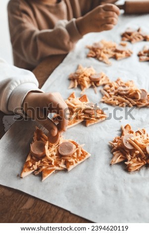 Child making pizza in the shape of a Christmas tree, activity idea.