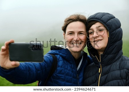 A Mother and son taking a selfie in the foggy nature