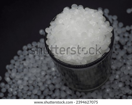 High density polyethylene plastic granules on a black background, this virgin polymer is one of the basic materials in the plastics industry Royalty-Free Stock Photo #2394627075