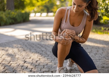 Woman runner hold her sports injured knee. Cropped Image of Woman Runner Hold Her Sports Injured Knee Outdoor. Injury From Workout Concept. Pain of Body Part and Bone Broken Theme Royalty-Free Stock Photo #2394628777