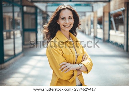 Portrait of young business woman standing outdoors. Close up portrait caucasian young happy woman with fresh and clean skin stands outside. Content gorgeous brunette 