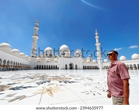 male tourist standing in front of the Sheikh Zayed Grand Mosque Royalty-Free Stock Photo #2394635977